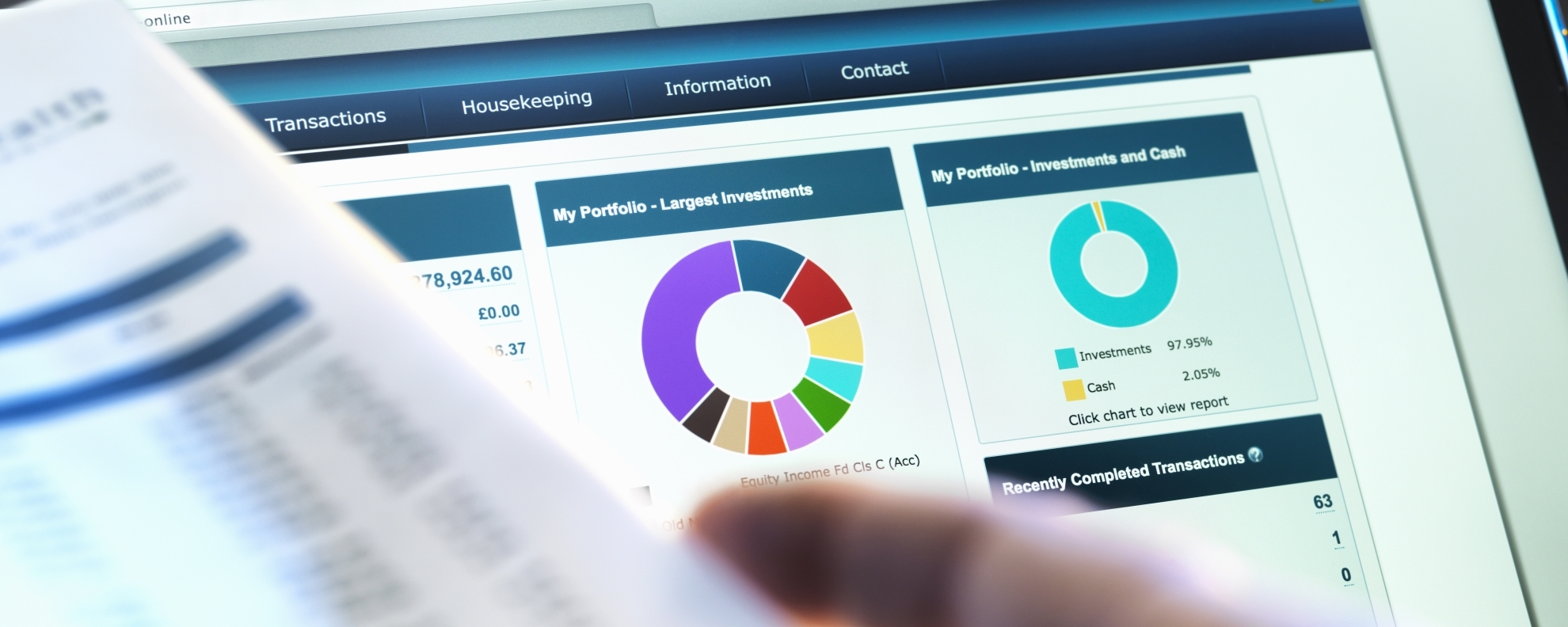 Financial documents in hand and on screen